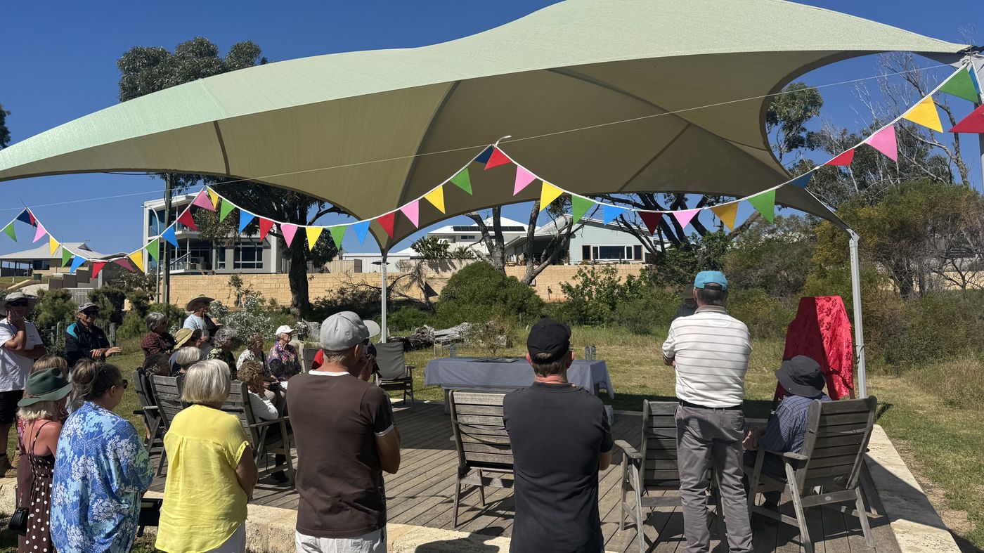 Residents gathered under the shade structure on the foreshore for the plaque unveiling