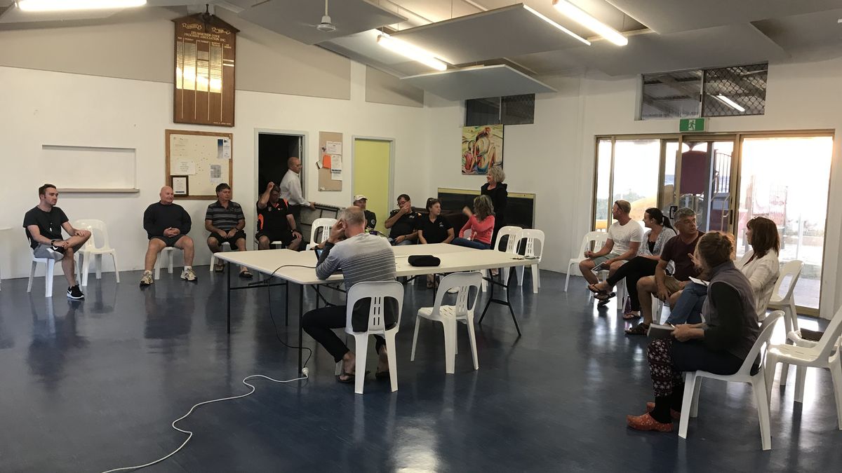 Residents seated in a circle at a community meeting in John Batten Hall